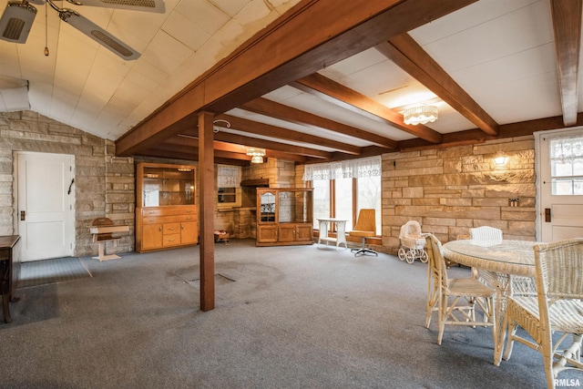 interior space featuring dark colored carpet, ceiling fan, and wooden walls