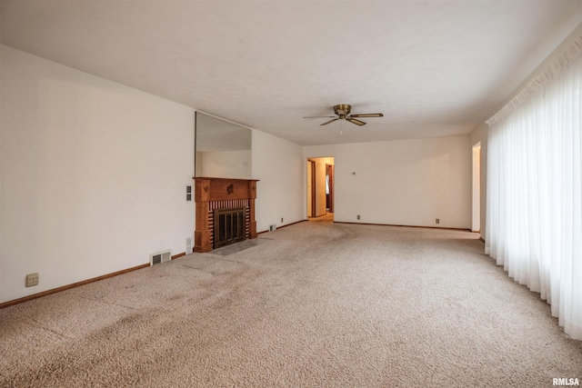 unfurnished living room with carpet, a fireplace, and ceiling fan