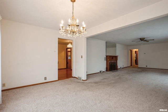 unfurnished living room featuring carpet and ceiling fan with notable chandelier