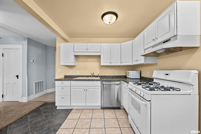 kitchen featuring white appliances, white cabinets, sink, a textured ceiling, and light tile patterned flooring