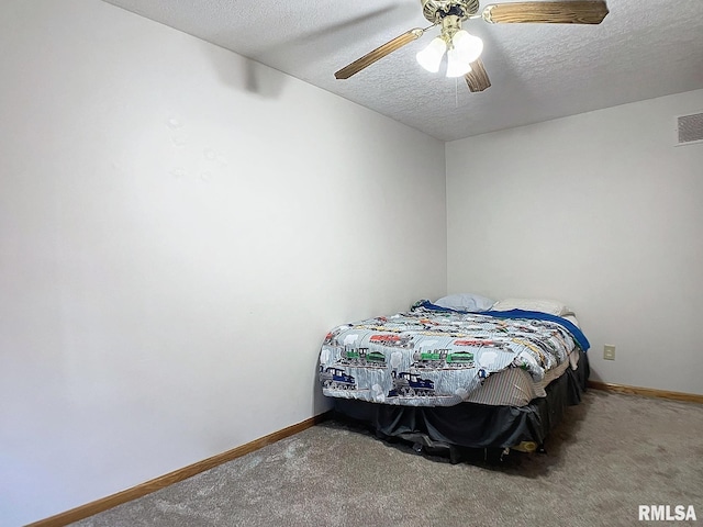 bedroom with ceiling fan, carpet, and a textured ceiling