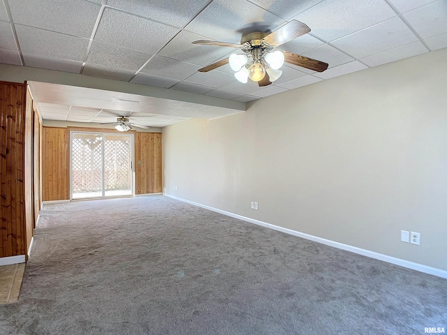 spare room with carpet, ceiling fan, and wood walls