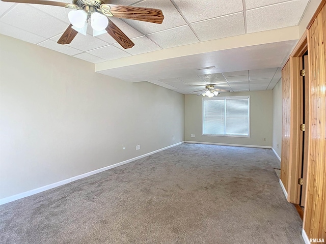 empty room featuring a paneled ceiling, ceiling fan, and carpet floors