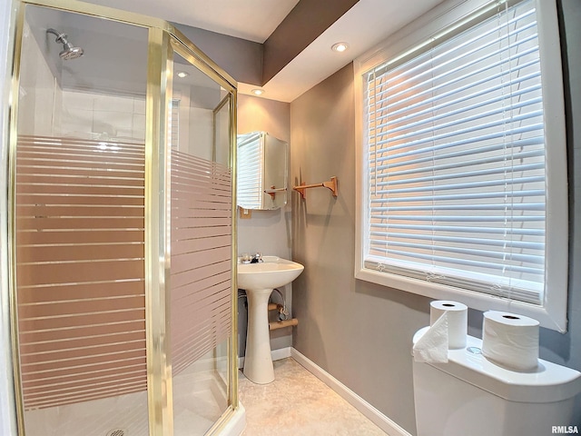 bathroom with a shower with shower door and toilet