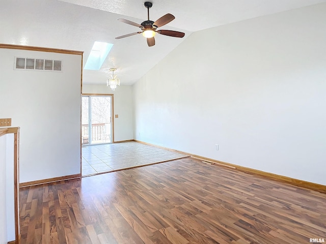 unfurnished living room featuring hardwood / wood-style flooring, ceiling fan with notable chandelier, vaulted ceiling with skylight, and a textured ceiling