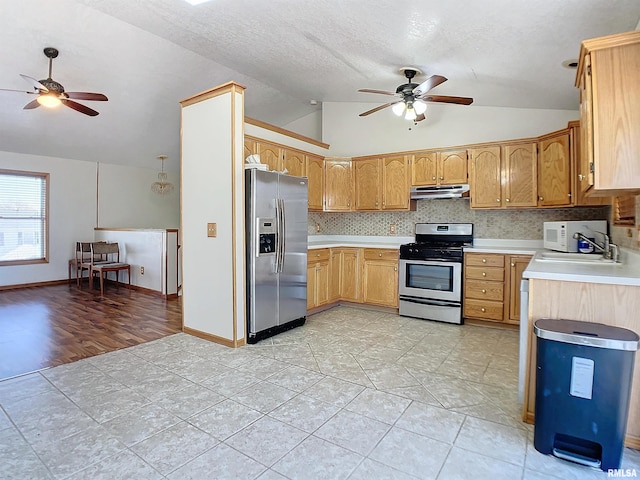 kitchen with tasteful backsplash, sink, vaulted ceiling, and appliances with stainless steel finishes