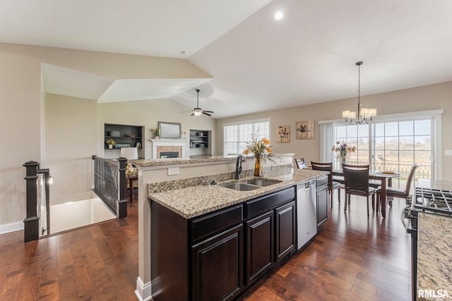 kitchen with stainless steel appliances, dark wood-type flooring, sink, decorative light fixtures, and lofted ceiling