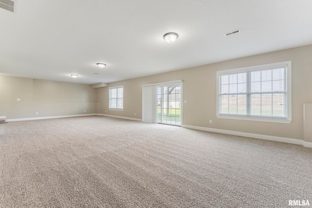 unfurnished room with carpet flooring and a wall mounted air conditioner