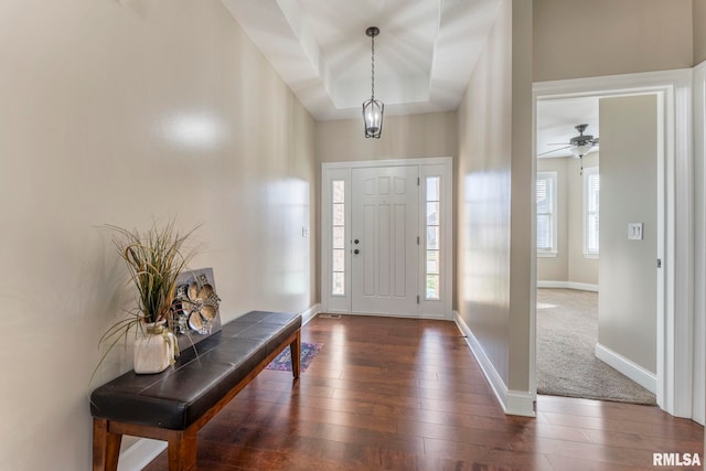 foyer entrance with a wealth of natural light, ceiling fan, and dark hardwood / wood-style floors