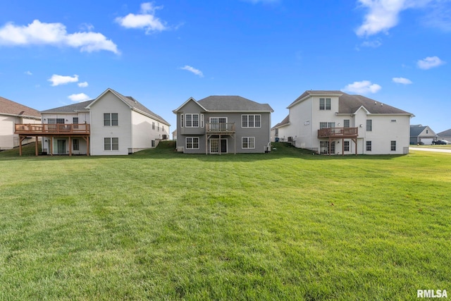 rear view of property with a lawn and a deck