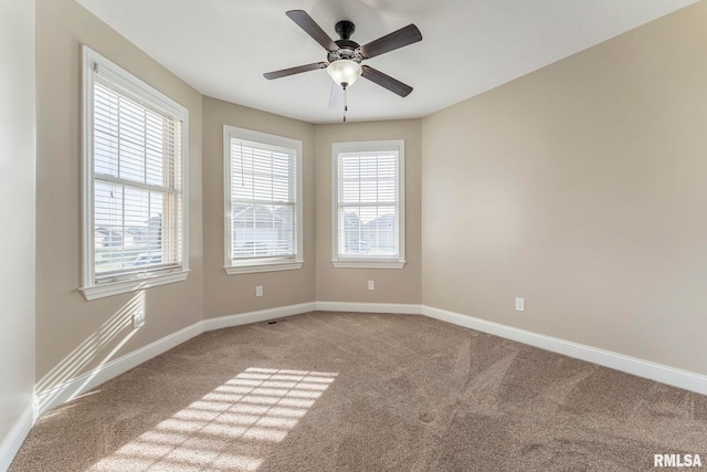 spare room featuring ceiling fan, carpet floors, and a wealth of natural light