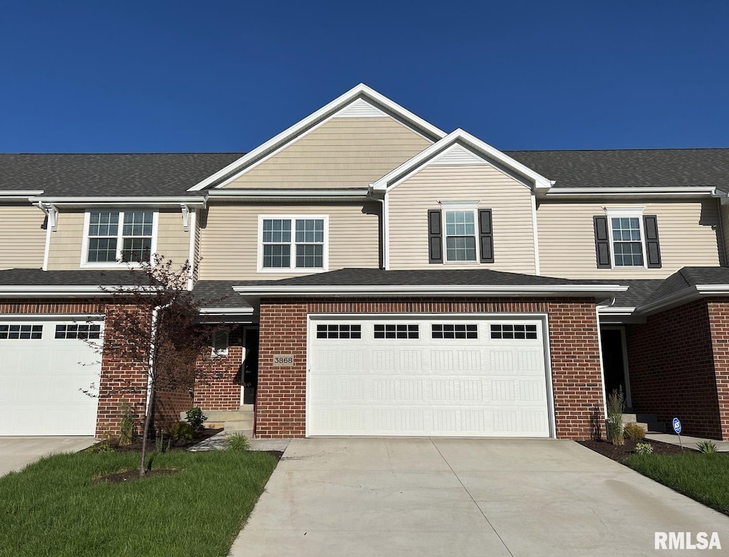 view of front of house featuring a garage, concrete driveway, and brick siding