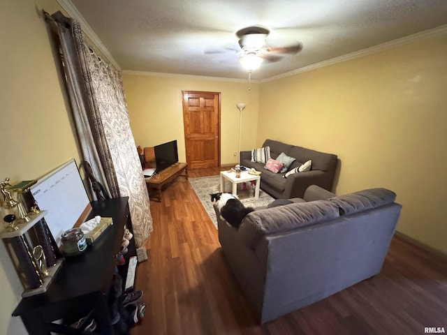 living room featuring ceiling fan, ornamental molding, and dark wood-type flooring