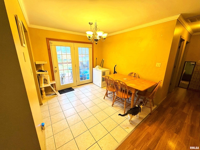 dining room with french doors, light hardwood / wood-style flooring, crown molding, and a notable chandelier