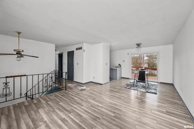 interior space featuring a textured ceiling, light wood-type flooring, and ceiling fan