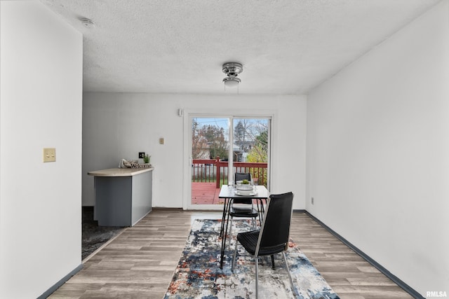 dining area featuring hardwood / wood-style floors and a textured ceiling