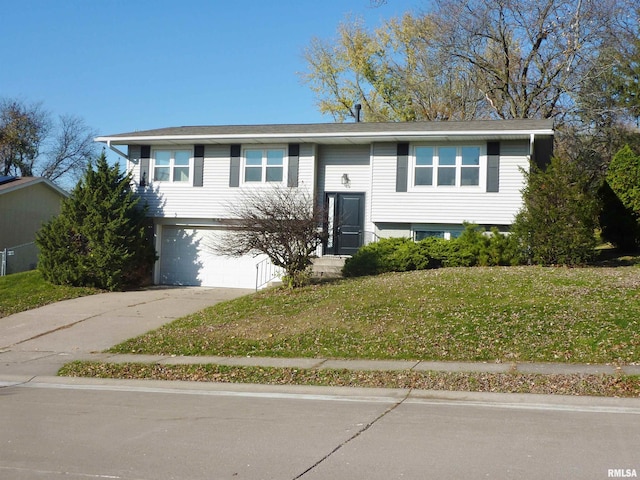 split foyer home with a garage and a front lawn