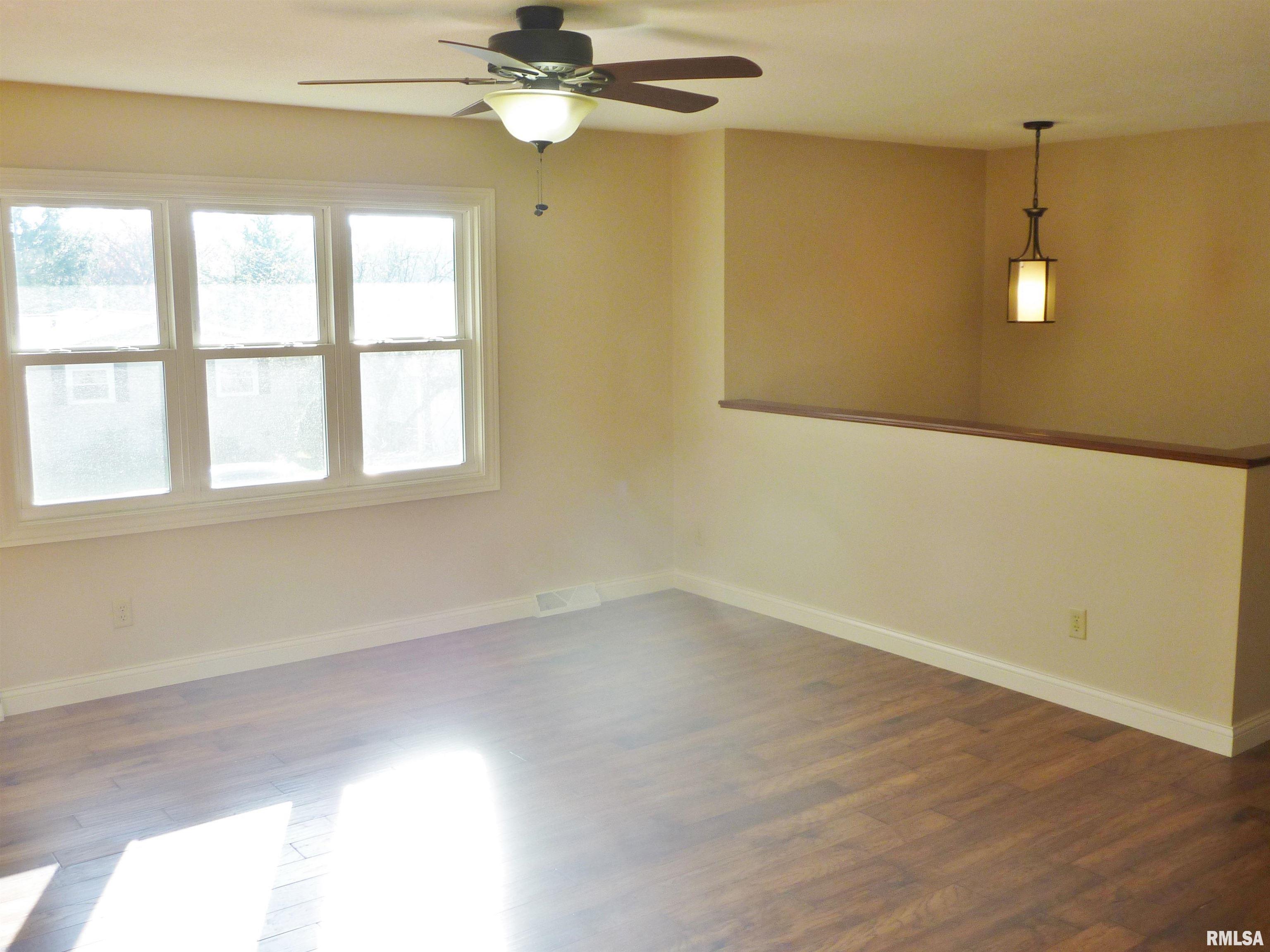 empty room featuring ceiling fan and dark wood-type flooring