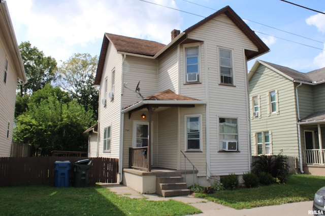 view of front of home with cooling unit and a front yard