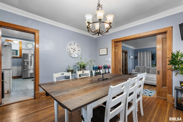 dining room with a notable chandelier, crown molding, and dark wood-type flooring