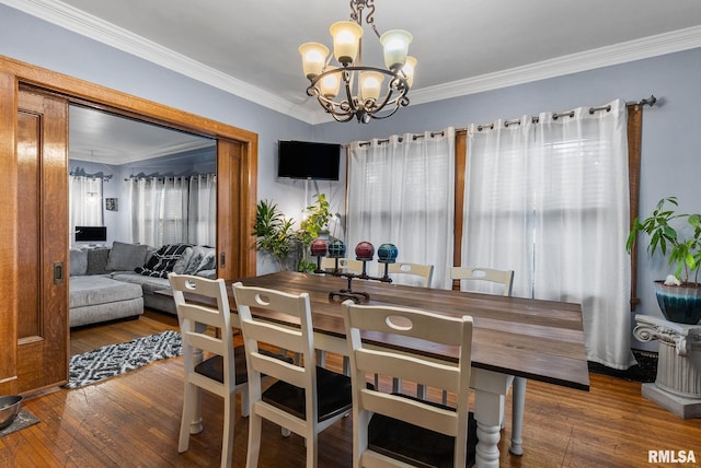 dining space featuring crown molding, dark hardwood / wood-style floors, and an inviting chandelier