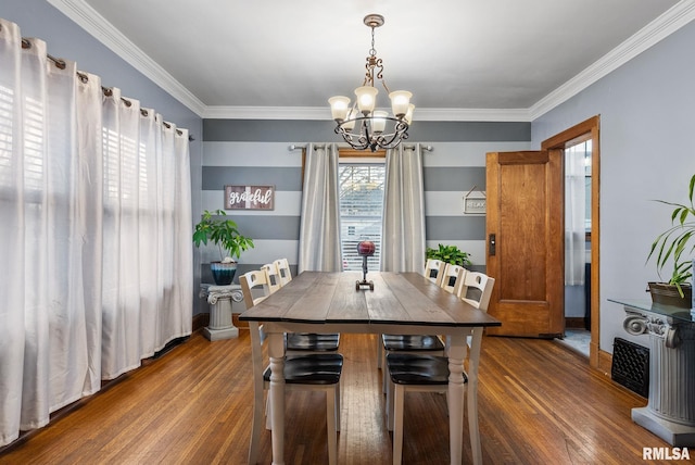 dining area with a notable chandelier, ornamental molding, and dark wood-type flooring