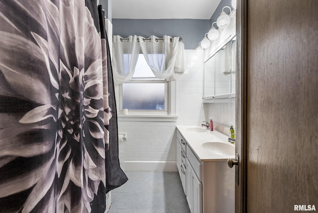 bathroom featuring vanity, tile walls, and tasteful backsplash