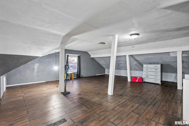 additional living space with vaulted ceiling and dark wood-type flooring