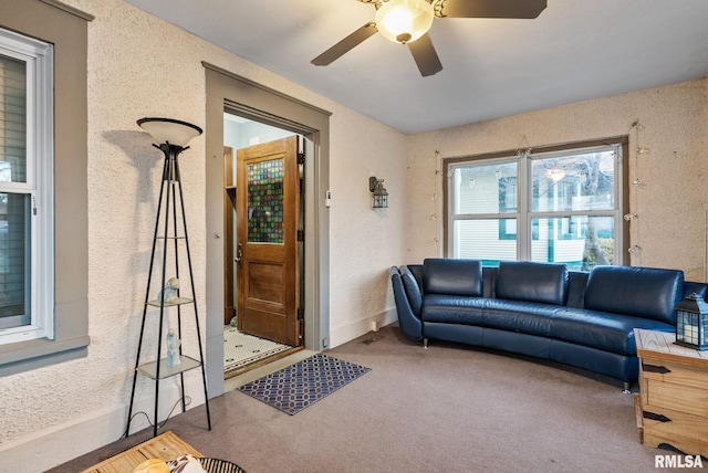 carpeted living room with ceiling fan