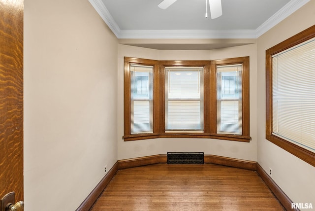 unfurnished room featuring ceiling fan, wood-type flooring, and ornamental molding