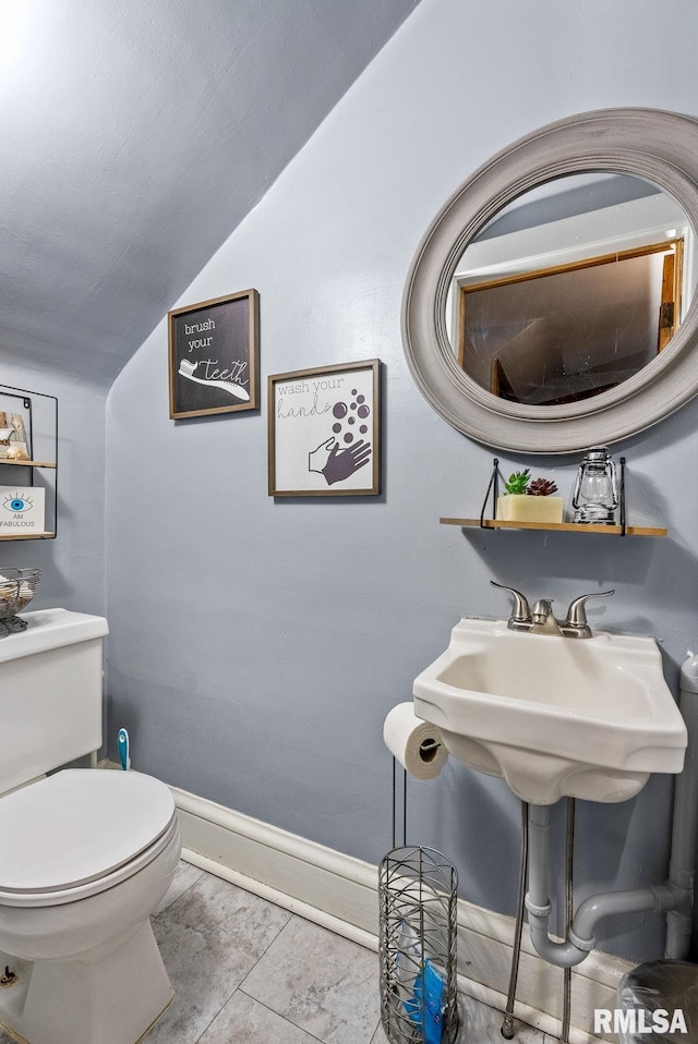 bathroom featuring tile patterned floors, vaulted ceiling, and toilet