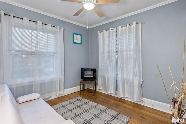 sitting room featuring ceiling fan, wood-type flooring, and ornamental molding