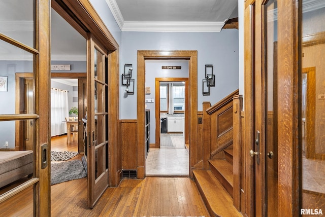 hallway featuring french doors, wood-type flooring, and ornamental molding