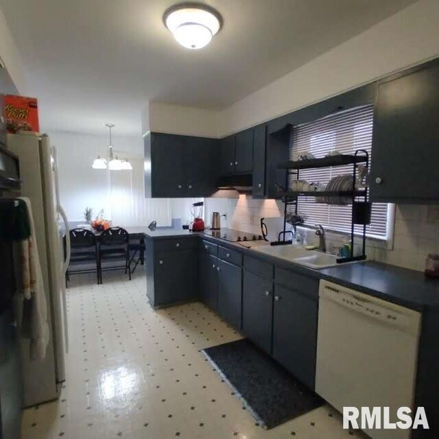 kitchen with white dishwasher, sink, pendant lighting, an inviting chandelier, and white cabinetry