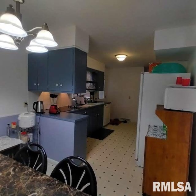 kitchen with blue cabinets and white refrigerator