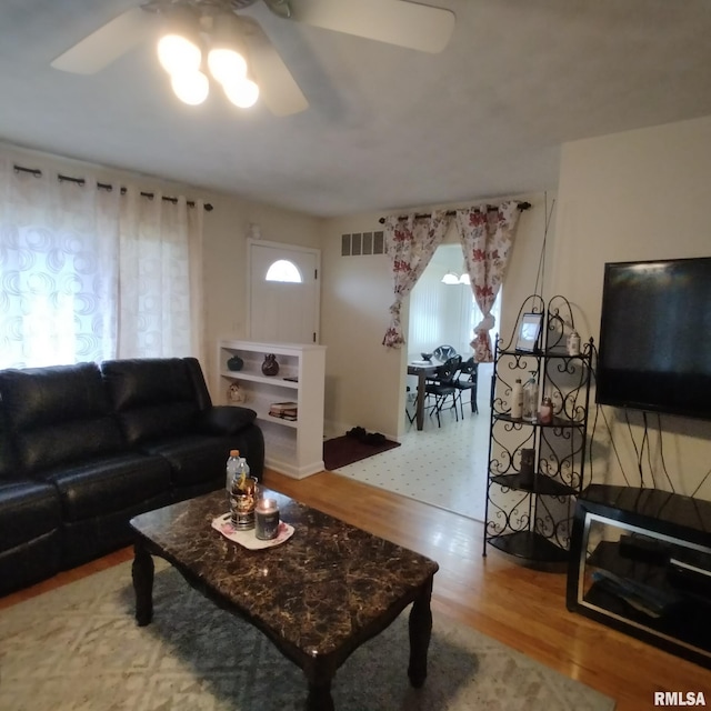 living room with wood-type flooring and ceiling fan