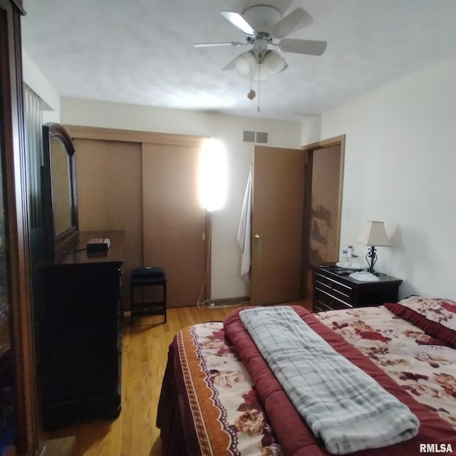 bedroom featuring a closet, light hardwood / wood-style flooring, and ceiling fan