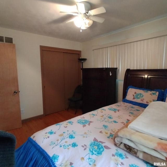 bedroom with ceiling fan, wood-type flooring, and a closet