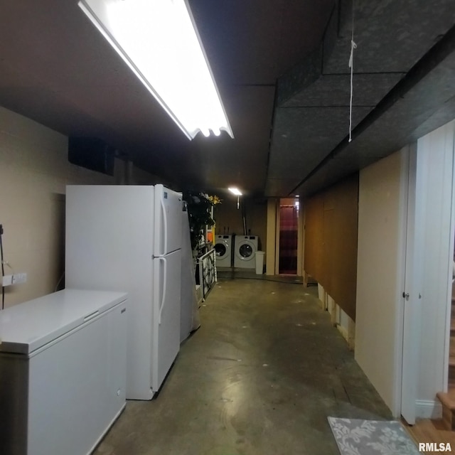 basement featuring white fridge, refrigerator, and washer and dryer