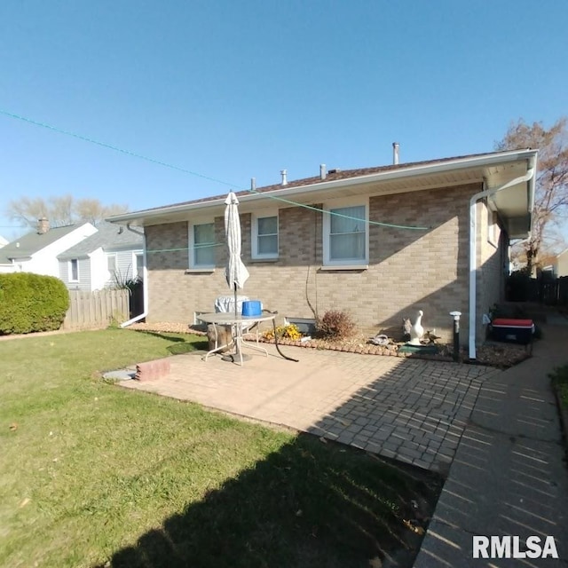 rear view of property featuring a patio area and a yard