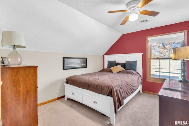 carpeted bedroom featuring ceiling fan, a textured ceiling, and vaulted ceiling