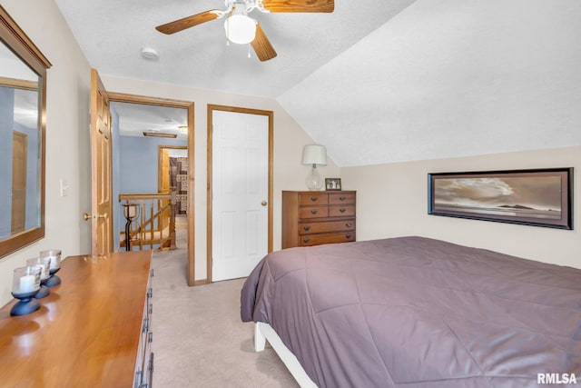 bedroom with a textured ceiling, ceiling fan, light carpet, and lofted ceiling