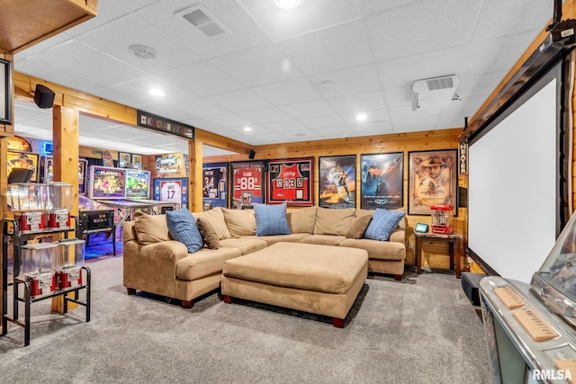 carpeted home theater room featuring a drop ceiling