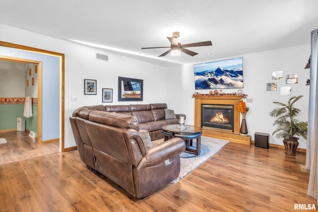 living room featuring ceiling fan, wood-type flooring, and a textured ceiling