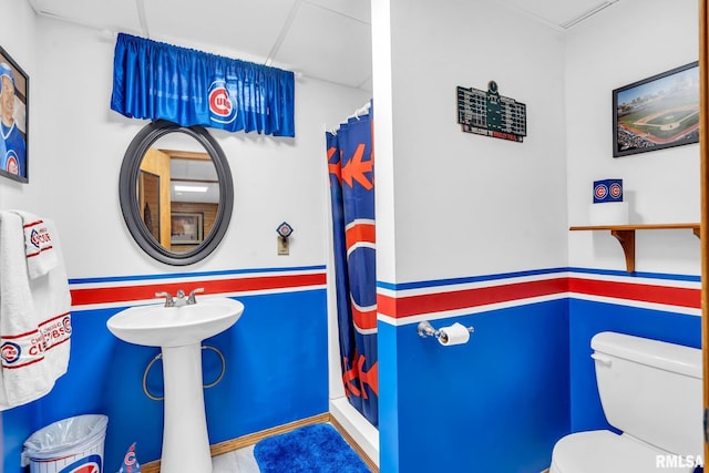 bathroom featuring curtained shower, toilet, and sink