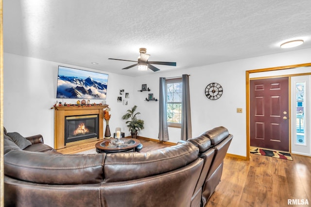 living room featuring a textured ceiling, light wood-type flooring, and a healthy amount of sunlight