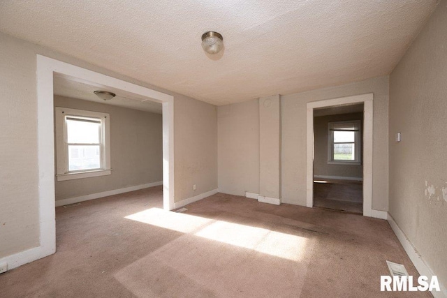 carpeted spare room with a textured ceiling