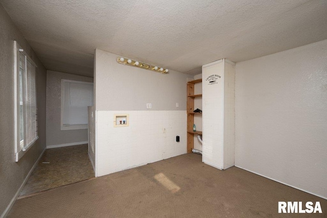 carpeted empty room with a textured ceiling