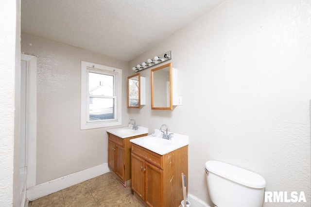 bathroom with vanity, a textured ceiling, and toilet