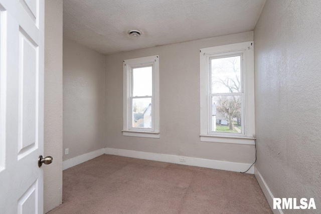 carpeted spare room with a textured ceiling